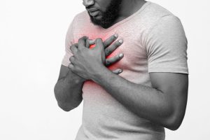 black young man suffering from acid reflux heartburn scaled